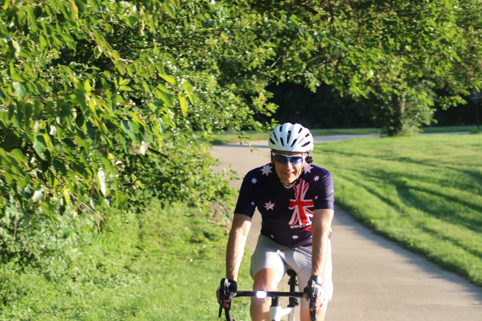 Wayne Kennedy riding a tree-lined trail in an Australia cycling jersey